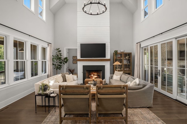 living room with a large fireplace, visible vents, a chandelier, and dark wood finished floors