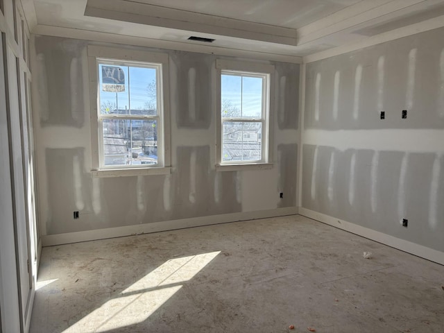 empty room with a tray ceiling and visible vents