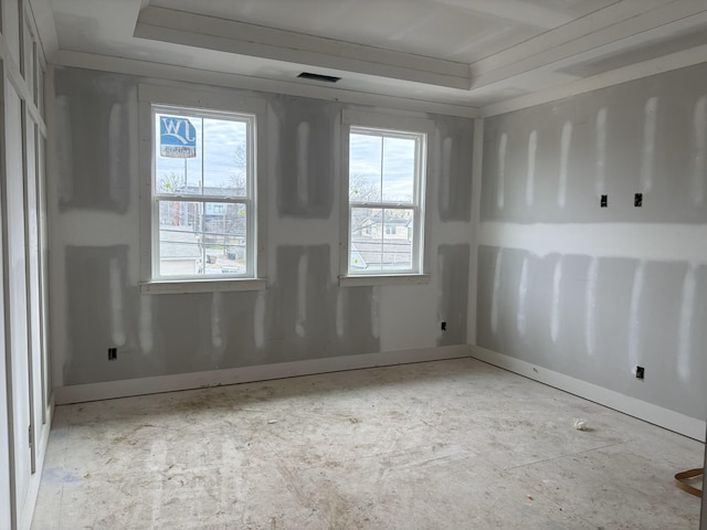 spare room with a tray ceiling and visible vents