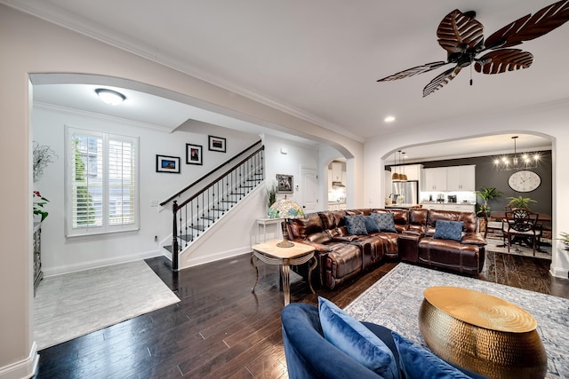 living room featuring arched walkways, baseboards, stairs, dark wood finished floors, and crown molding