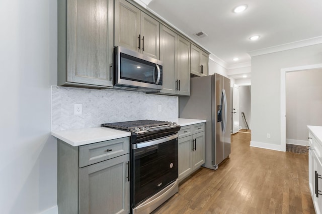 kitchen with stainless steel appliances, light countertops, and gray cabinetry