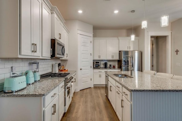 kitchen featuring pendant lighting, appliances with stainless steel finishes, and white cabinets