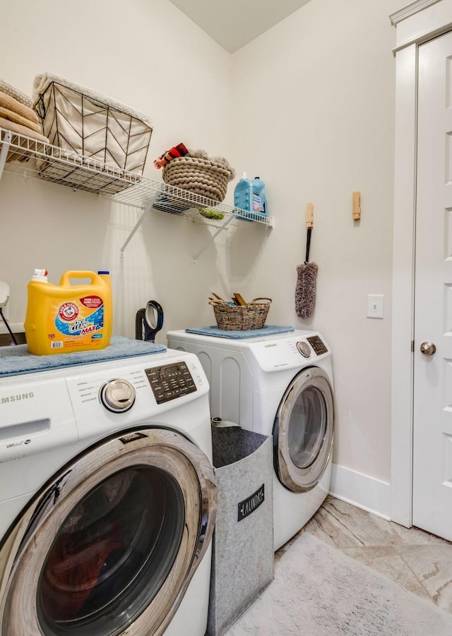 clothes washing area featuring laundry area, baseboards, and separate washer and dryer