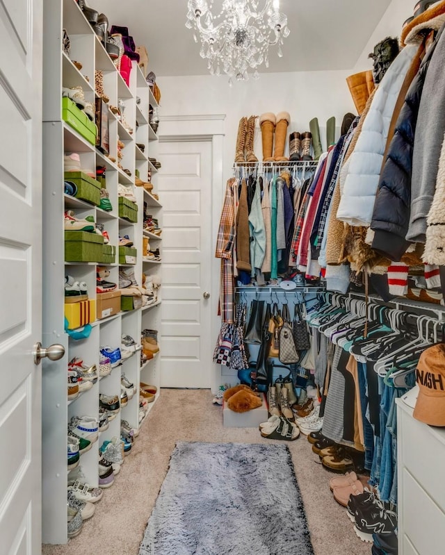 walk in closet with an inviting chandelier and carpet