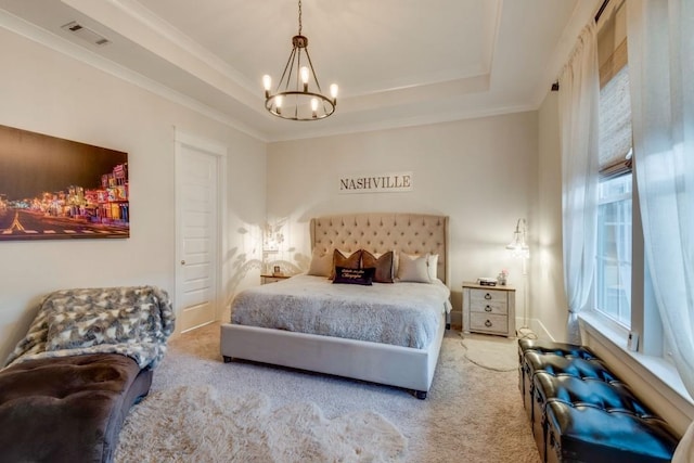 bedroom with visible vents, crown molding, a tray ceiling, and carpet flooring