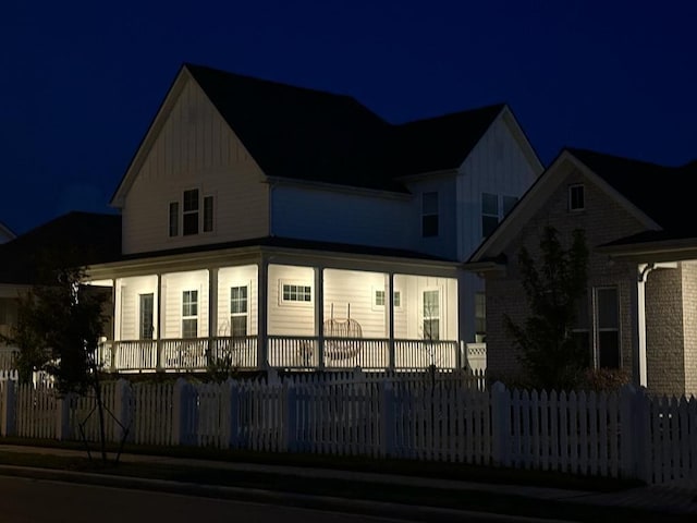 exterior space featuring a porch and a fenced front yard