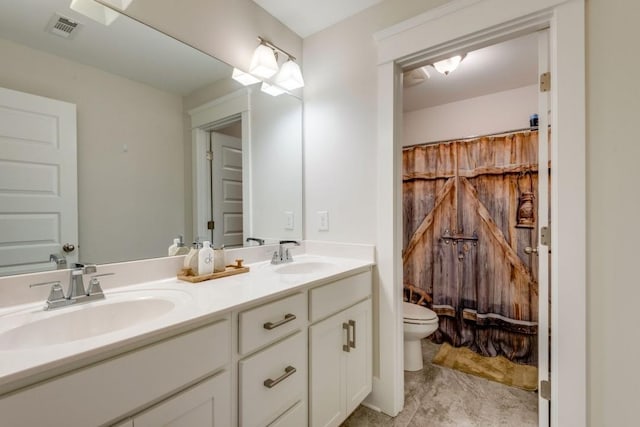 full bathroom with toilet, double vanity, a sink, and visible vents