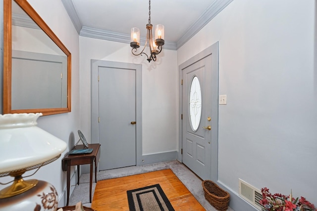 foyer entrance with baseboards, an inviting chandelier, light wood-style flooring, and crown molding