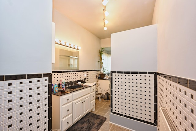 bathroom with wainscoting, vanity, tile walls, and tile patterned floors