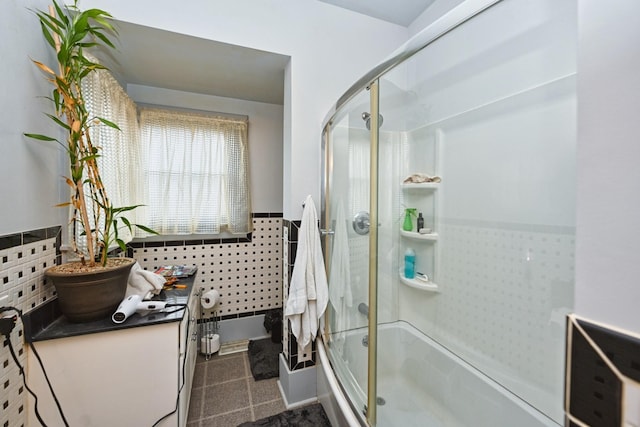 bathroom featuring bath / shower combo with glass door and vanity