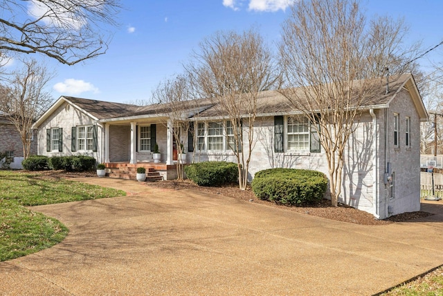 single story home featuring a porch and brick siding