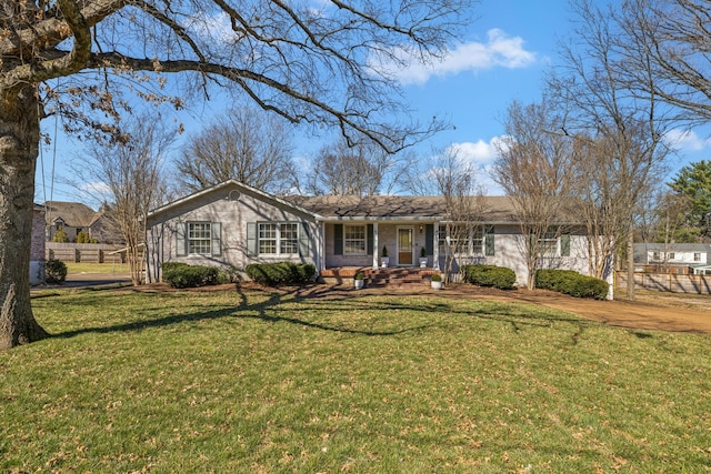 ranch-style house featuring covered porch, brick siding, a front yard, and fence