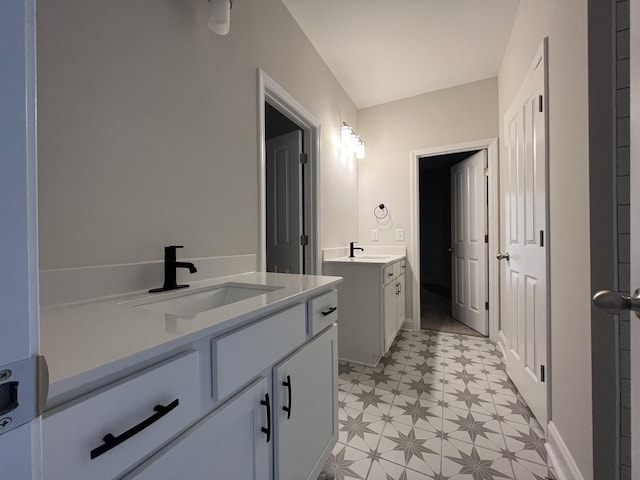 bathroom with two vanities, a sink, and tile patterned floors