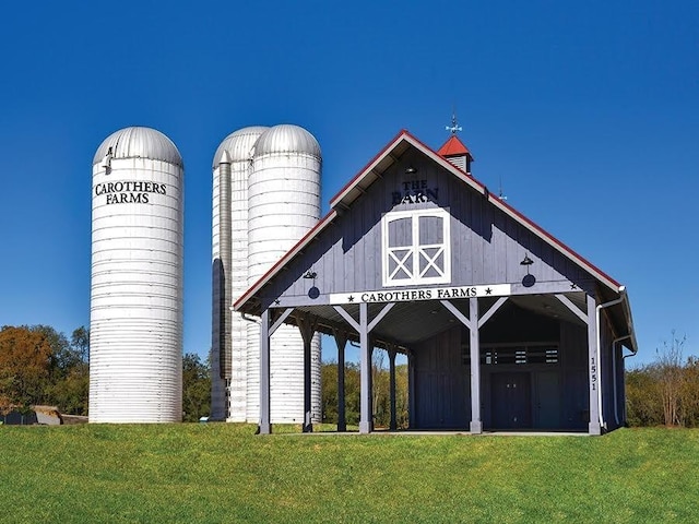 surrounding community with an outdoor structure, a lawn, and a barn