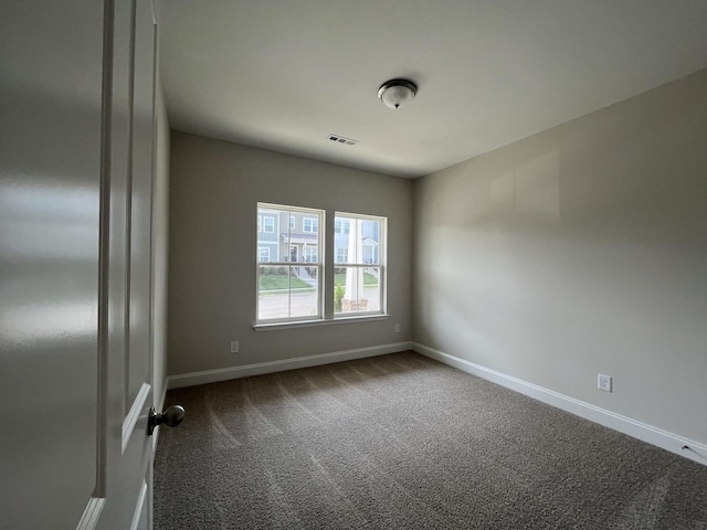 carpeted empty room featuring visible vents and baseboards