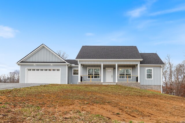 view of front of property with a garage, a porch, board and batten siding, and roof with shingles