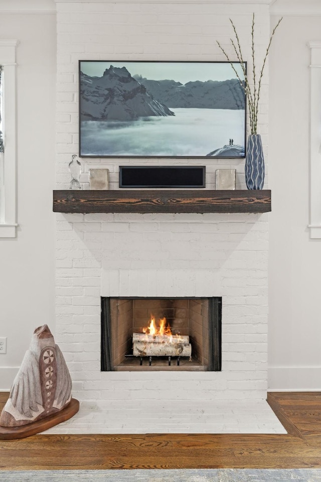 interior details with a fireplace, wood finished floors, and baseboards