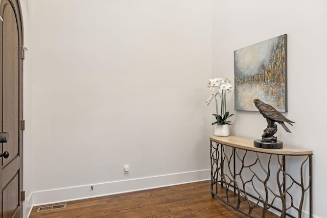 interior space featuring dark wood-type flooring, visible vents, and baseboards