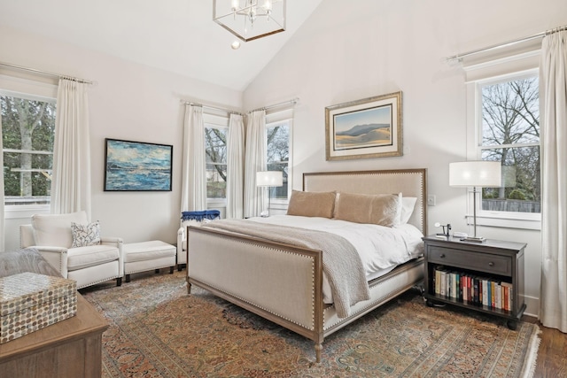 bedroom with dark wood-style floors, multiple windows, and vaulted ceiling