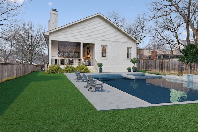 back of property featuring a yard, brick siding, a fenced backyard, and a fenced in pool