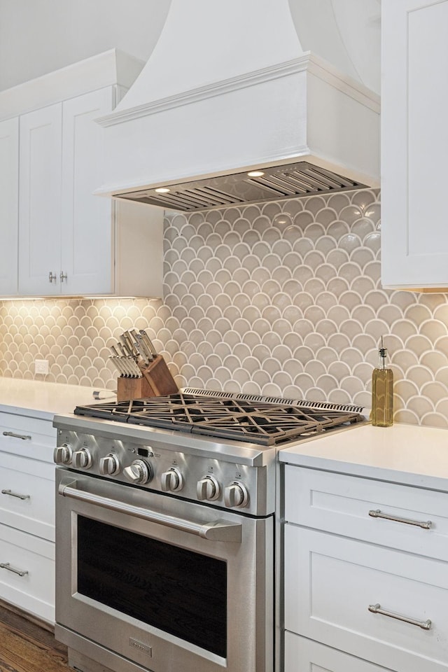 kitchen with high end stainless steel range oven, white cabinets, and light countertops