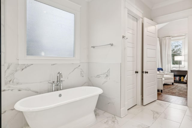 full bath with a soaking tub and marble finish floor