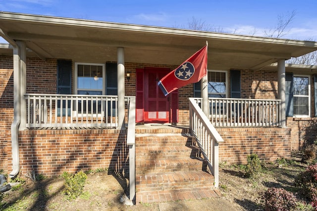 view of front of home featuring a porch and brick siding