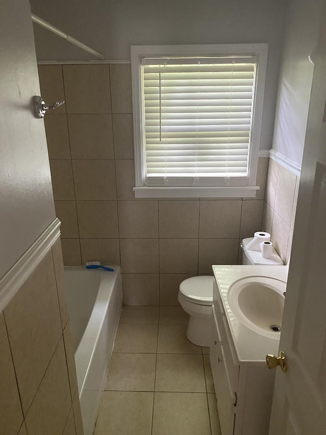 full bathroom with toilet, vanity, tile walls, and tile patterned floors