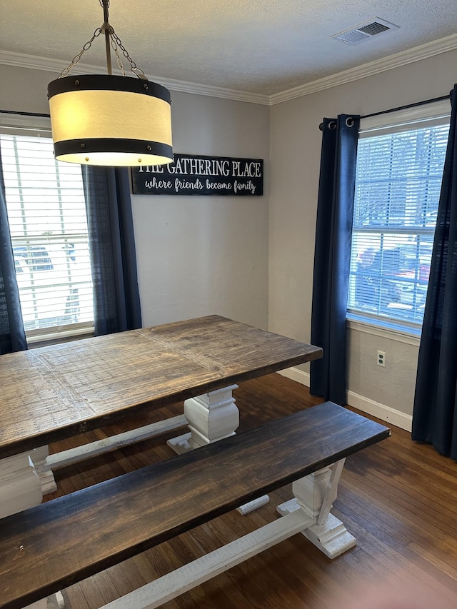 unfurnished dining area featuring ornamental molding, dark wood-style flooring, visible vents, and plenty of natural light