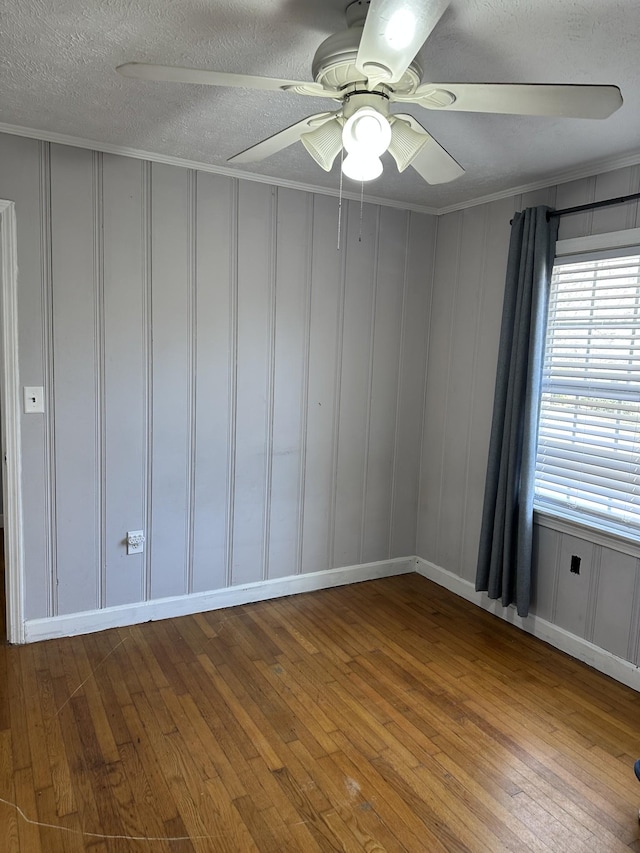 spare room with ornamental molding, ceiling fan, a textured ceiling, and light wood finished floors