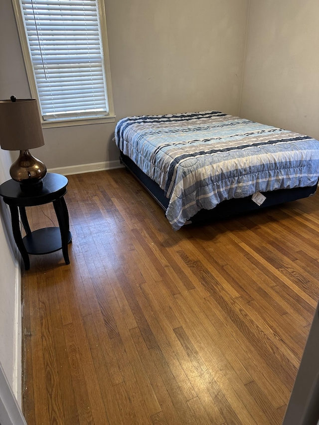 bedroom featuring dark wood-style floors and baseboards