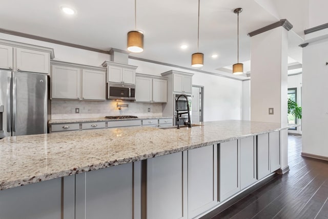 kitchen featuring gray cabinets, light stone counters, stainless steel appliances, and decorative light fixtures