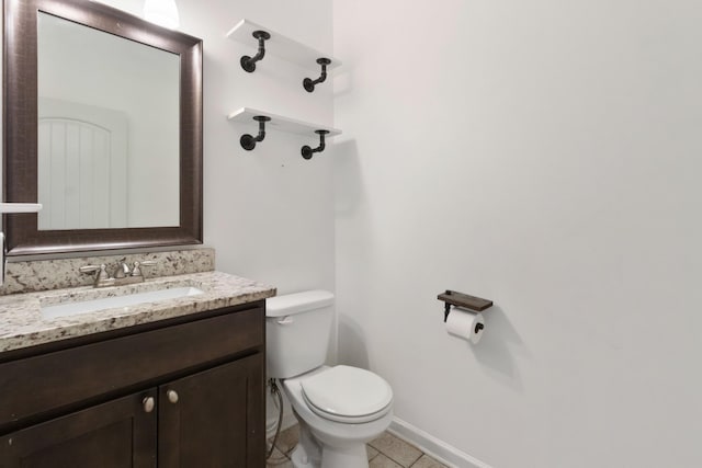 half bath featuring toilet, tile patterned flooring, vanity, and baseboards