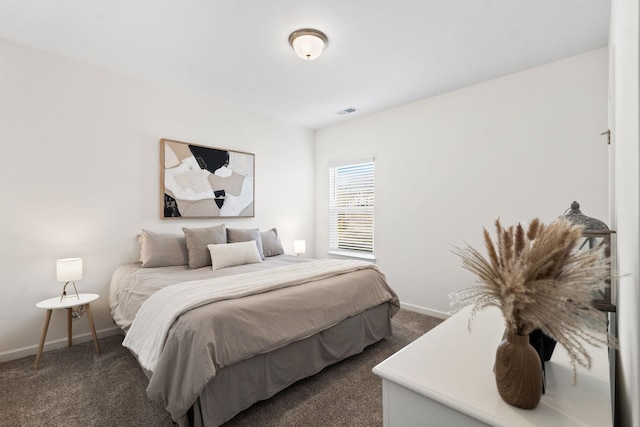 bedroom featuring dark colored carpet, visible vents, and baseboards