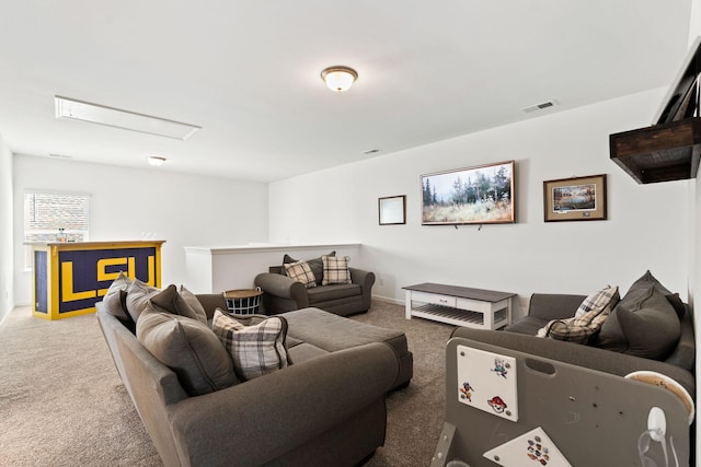 living room featuring carpet floors, attic access, visible vents, and baseboards