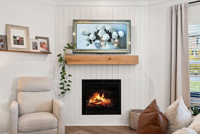 sitting room with wood finished floors and a glass covered fireplace