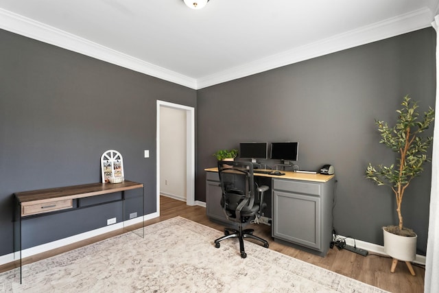 home office featuring crown molding, light wood-style flooring, and baseboards