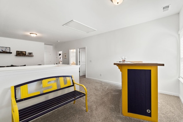 interior space featuring a bar, attic access, visible vents, and baseboards