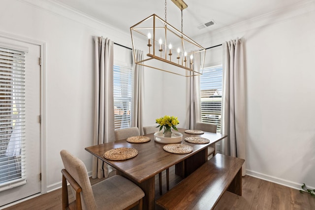 dining area with ornamental molding, baseboards, visible vents, and dark wood-type flooring