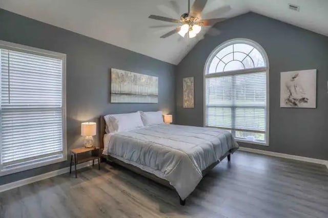 bedroom featuring dark wood-style floors, vaulted ceiling, visible vents, and baseboards