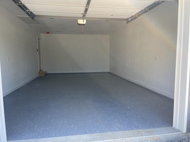 garage featuring a garage door opener and baseboards