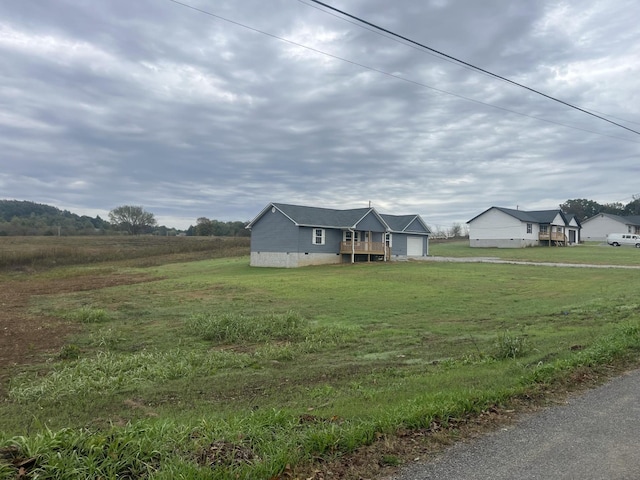 view of front of property featuring a garage, crawl space, a rural view, and a front lawn