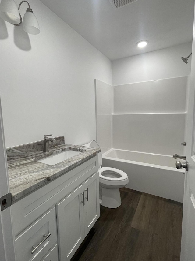 bathroom featuring vanity, shower / tub combination, toilet, and wood finished floors