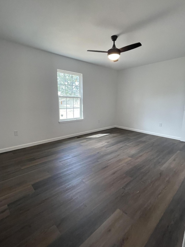 empty room with ceiling fan, baseboards, and dark wood-style floors