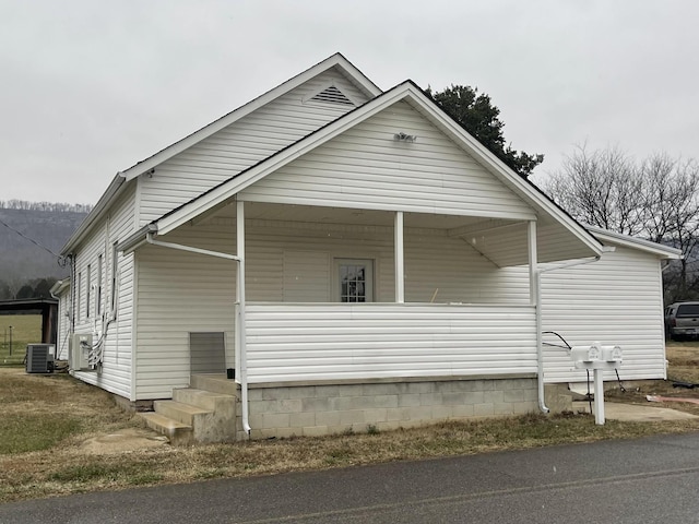 view of home's exterior with covered porch and central AC