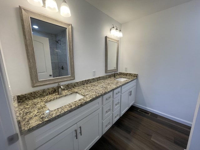 full bathroom featuring wood finished floors, a sink, visible vents, and baseboards