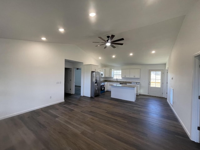 kitchen featuring a center island, light countertops, appliances with stainless steel finishes, open floor plan, and white cabinets