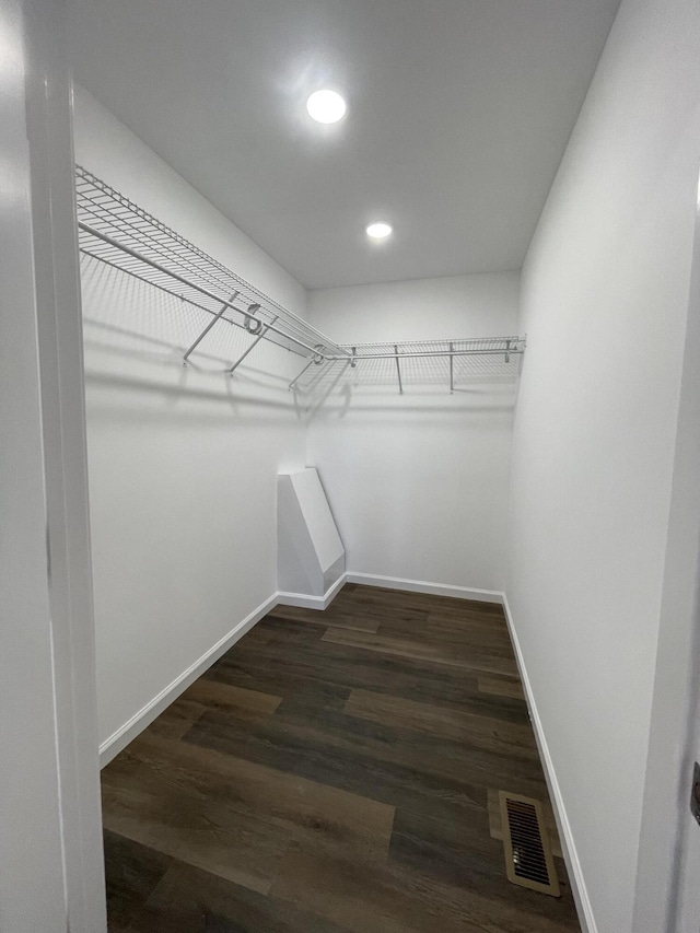 spacious closet featuring dark wood-style flooring and visible vents