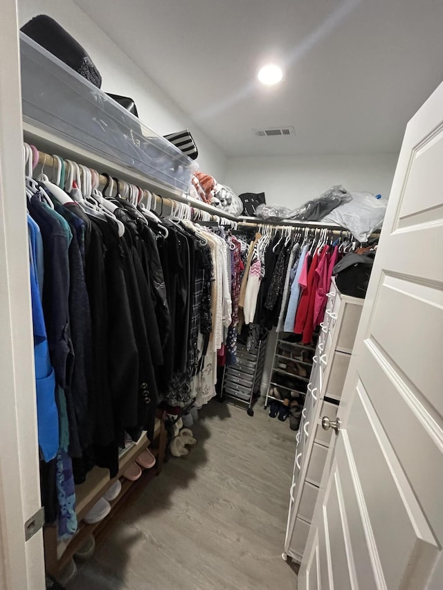 walk in closet with wood finished floors and visible vents