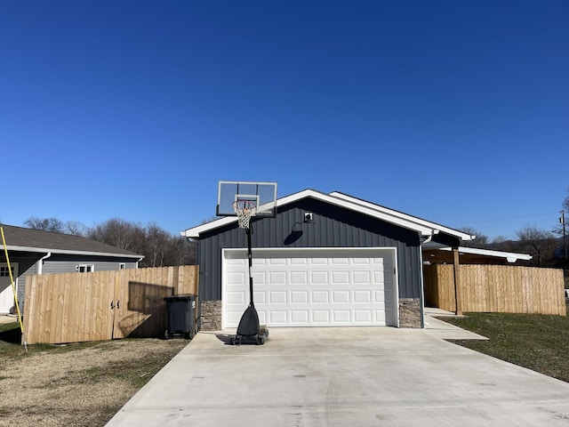 view of property exterior with board and batten siding, stone siding, a yard, and fence